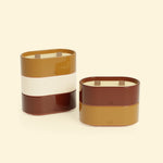 Bougies Totem S Forest Brun terre de sienne – Citronnelle & Fleur d’oranger et Rouge oxyde – Citronnelle & Géranium, deux bougies ovales à double mèche en bois, posées sur un fond beige clair. 