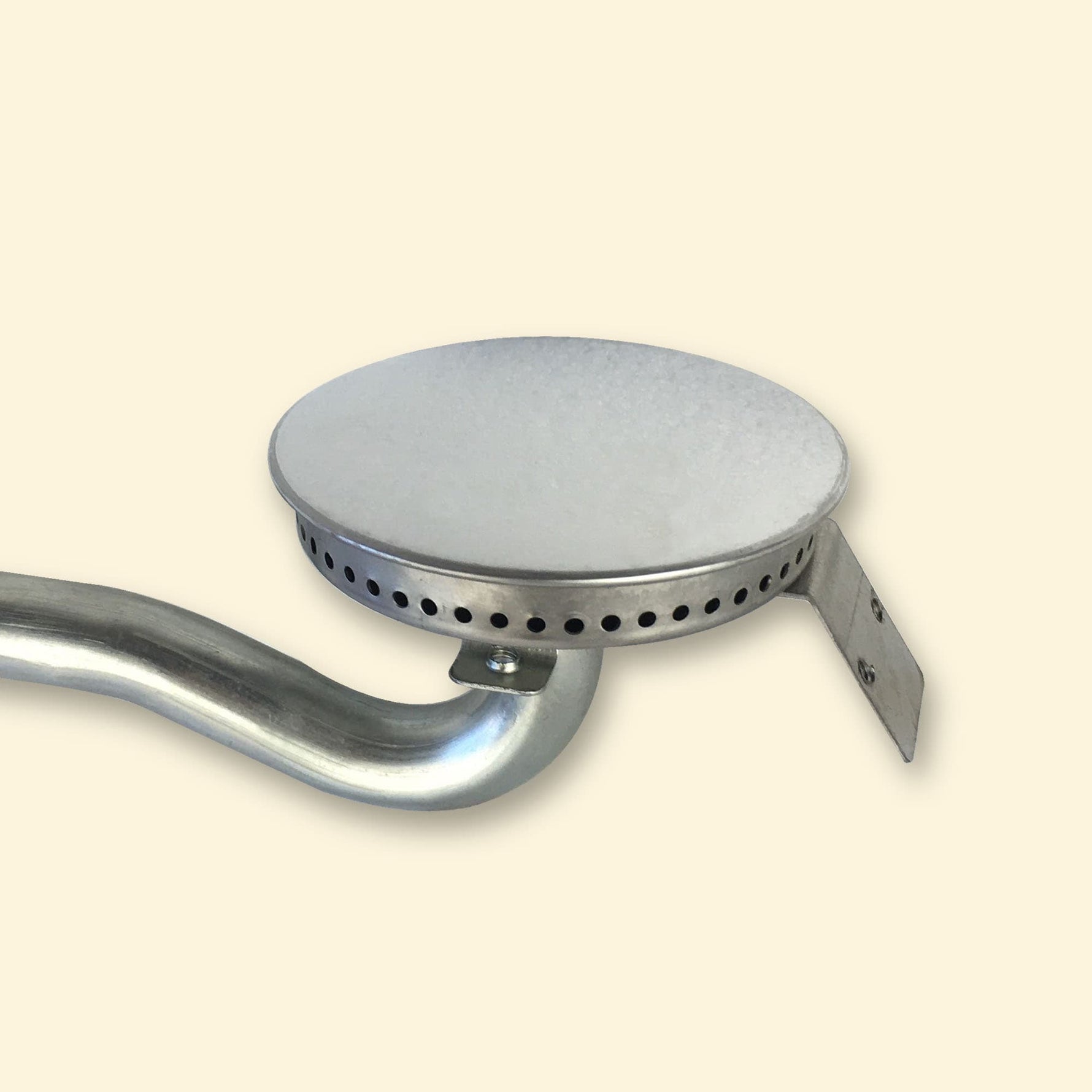 Brûleur en acier pour plancha gaz Vivaplancha, avec tête ronde perforée et tube courbé, présenté sur fond beige.
