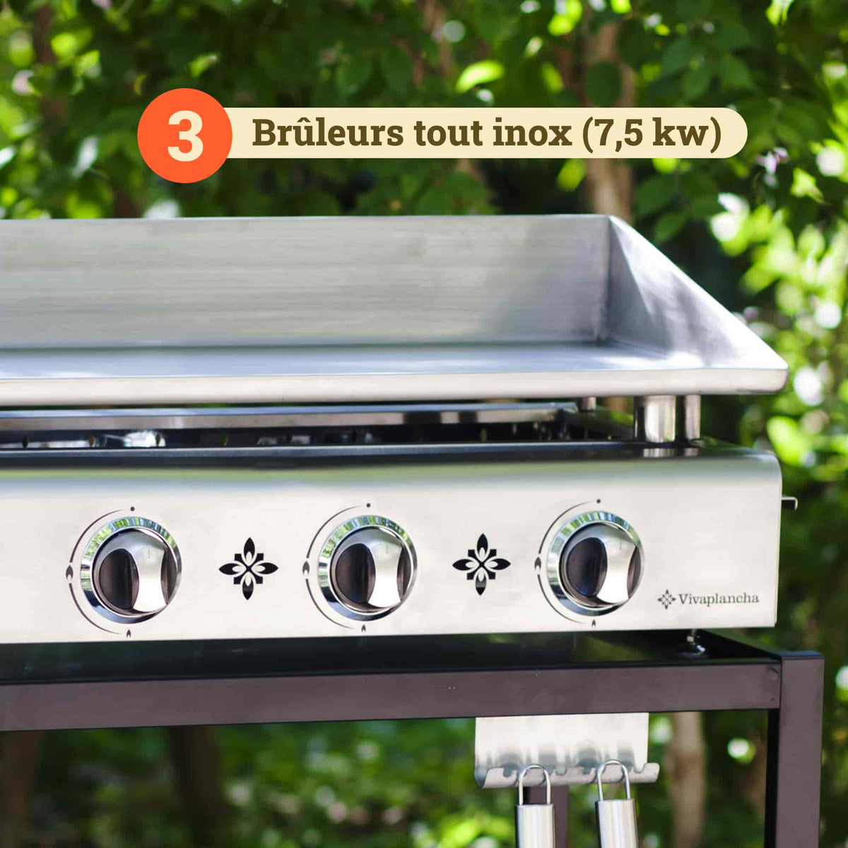 Plano aproximado da plancha Vivaplancha mostrando os seus três queimadores totalmente em inox (7,5 kW), com os botões de regulação na parte frontal e um emblema a ilustrar a potência dos queimadores.