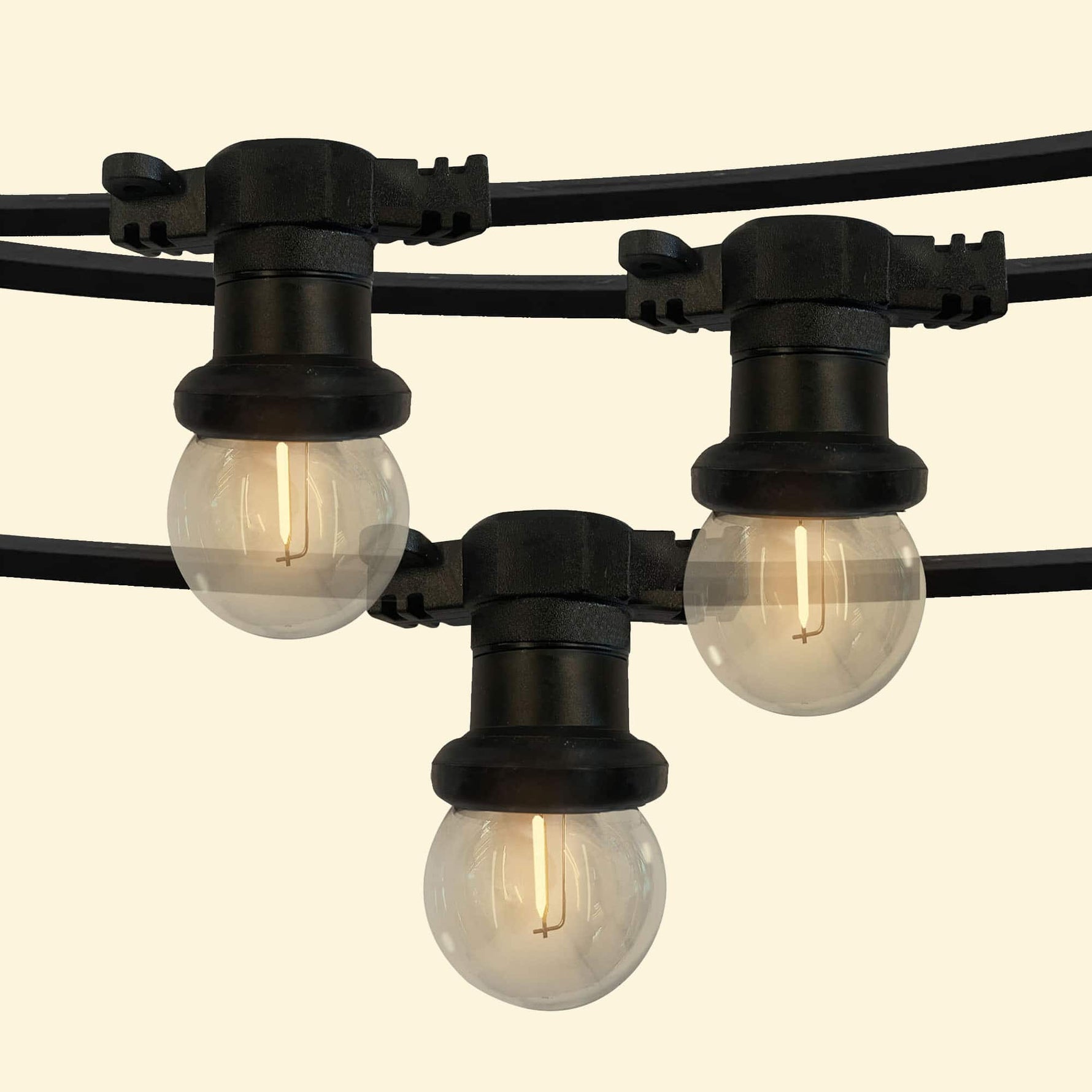 Guirlande lumineuse d’extérieur avec ampoules rondes transparentes à filament LED, montées sur un câble noir résistant, parfaite pour éclairer et décorer terrasses, pergolas ou jardins.