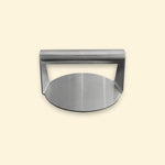 Presse à smash burger en inox vue de face, avec une poignée cylindrique et une base ronde plate.