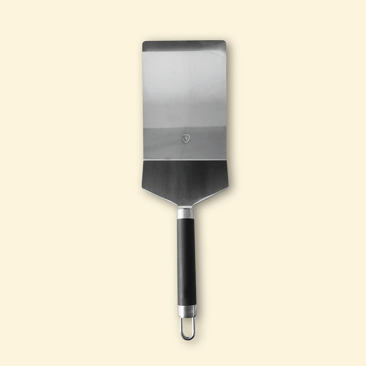 Grande spatule de cuisine en inox avec manche noir, vue de face sur fond clair.